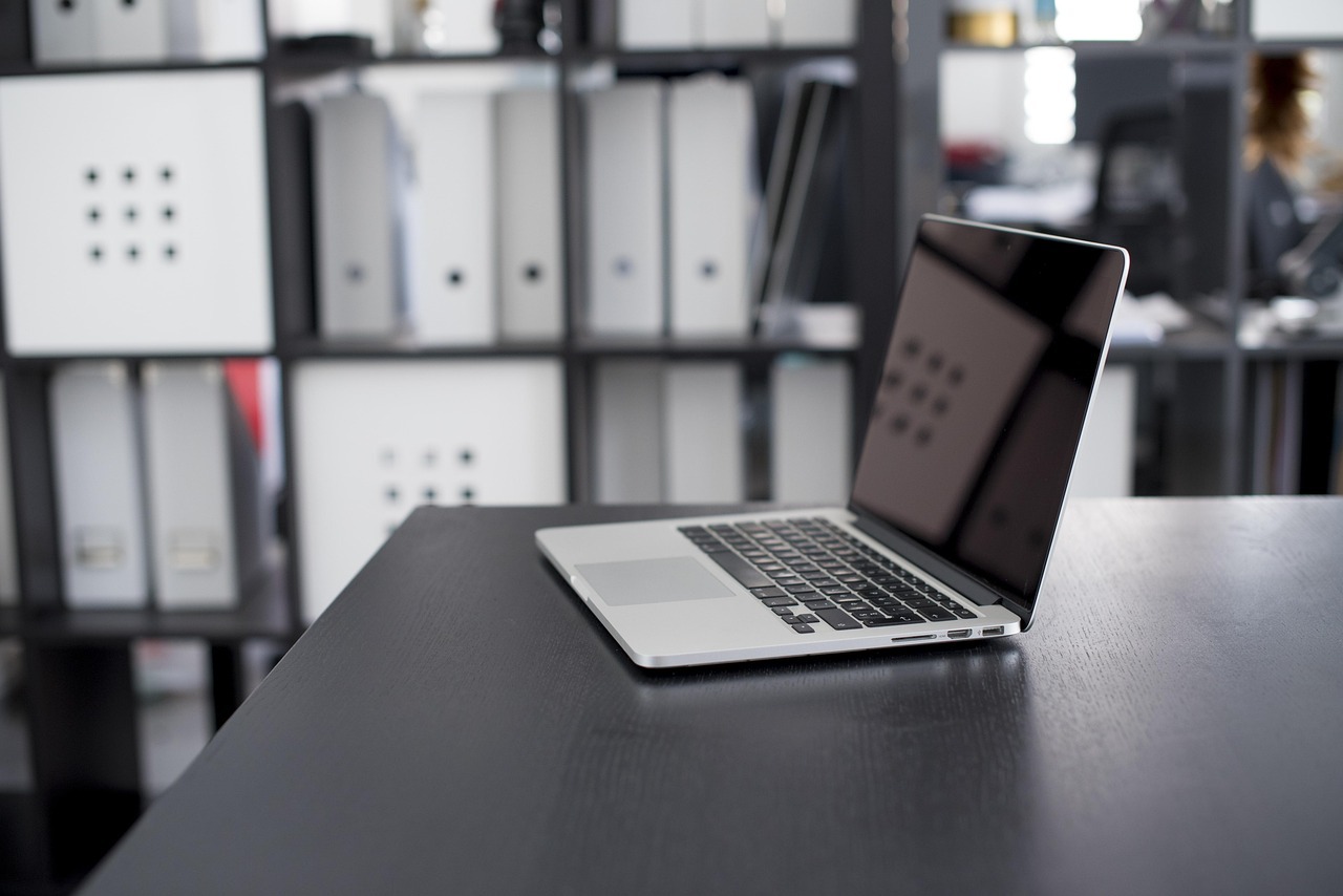 Laptop auf Schreibtisch in modernem Büro als Symbol für digitale Baugutachter Online-Beratung.